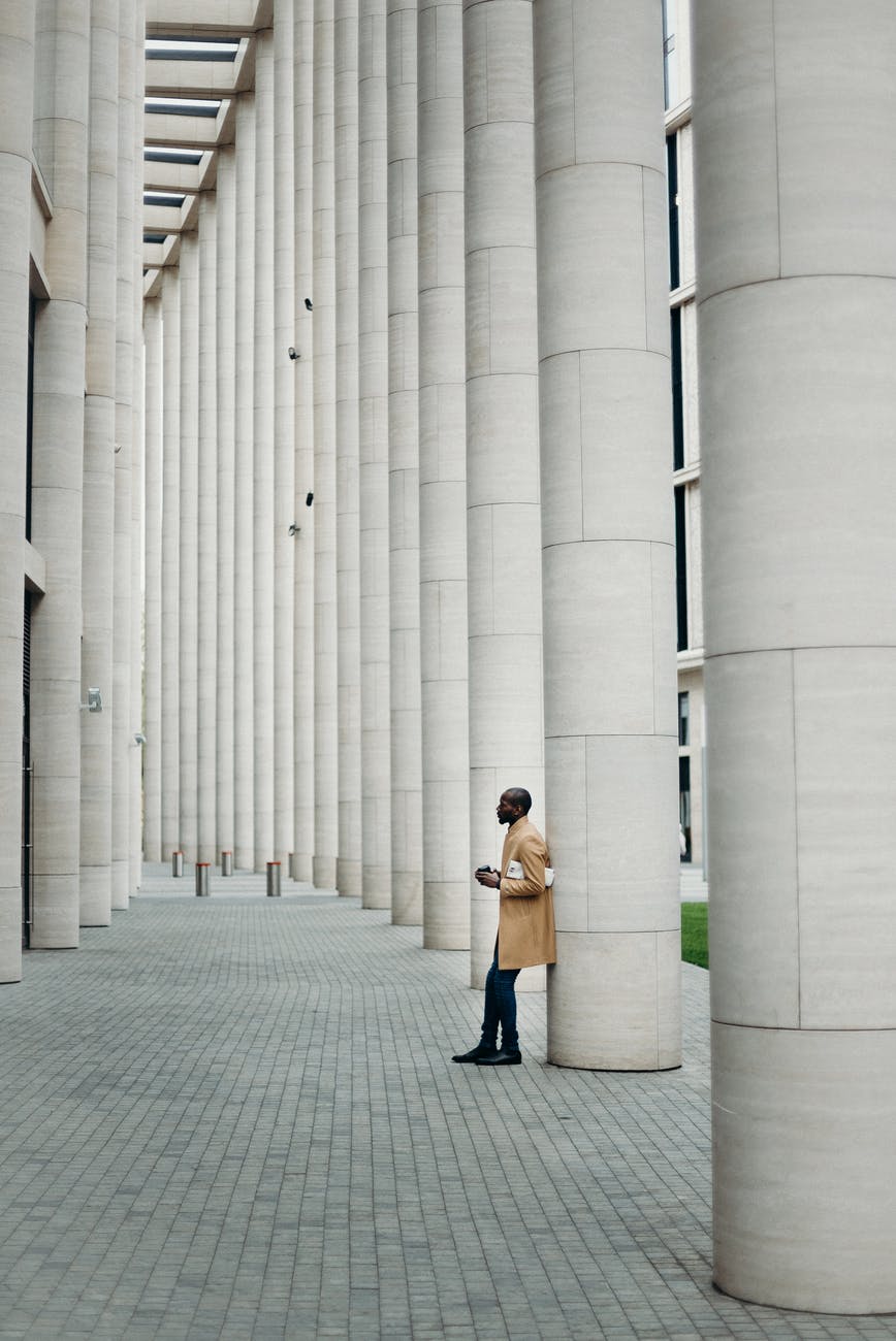 man leaning on post