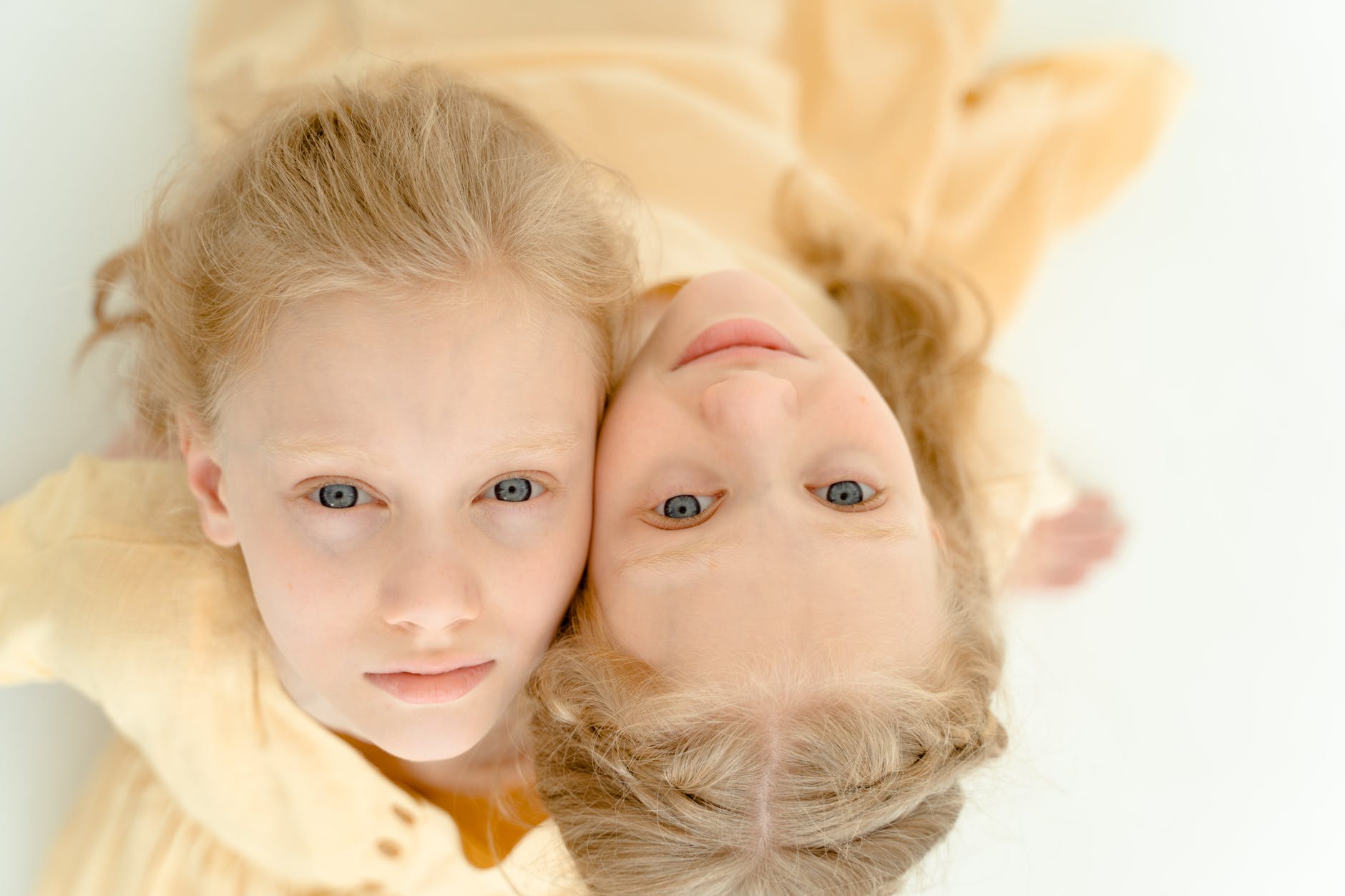 girl in yellow shirt lying on bed